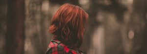 woman with red hair in woods