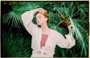 woman-with-closed-eyes-touching-a-leaf-of-a-palm