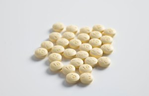 yellow pills on white background.