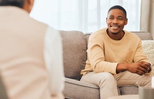 Young handsome black man sitting in counseling sessions with his psychodynamic therapist