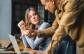 Man and woman talking at a computer