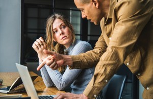 Man and woman talking at a computer