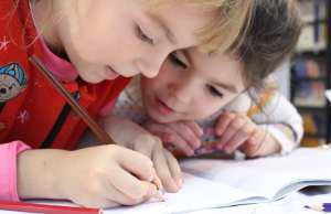 girls-on-desk-looking-at-notebook