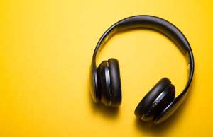 Black headphones against a yellow background.