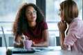 Two women talking at work in an office with a laptop in front of them