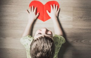 boy wearing green shirt with red paper heart