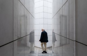 man walking between white walls