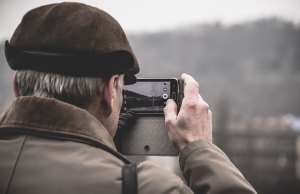 older man taking picture on cell phone