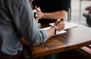 two people working at a wood table