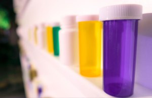 purple, yellow white and green pill bottles