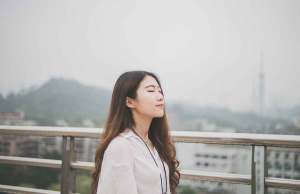 woman in white shirt standing on bridge by mountain