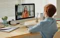 redhead child in blue shirt sitting at desk on computer video chat