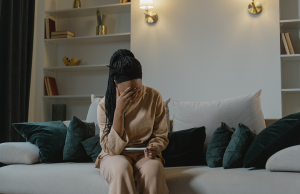 woman sitting on couch holding pregnancy test