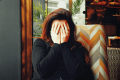 Woman with hands covering her face