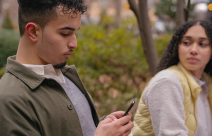 woman-looking-jealously-at-man-while-on-his-phone