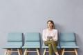 White woman sitting with tablet in a waiting room