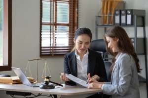 Woman discussing paperwork in an office with attorney