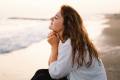 Woman sitting and thinking on the beach