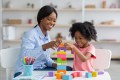 Adorable black kid working with her therapist