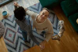 Queer couple dancing in a living room