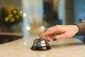 Hand ringing a bell on a counter